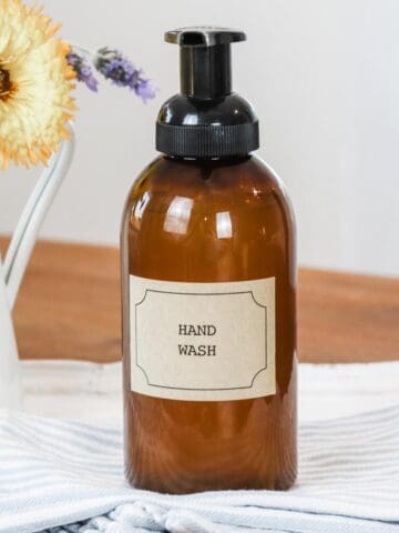 Amber coloured foaming hand soap pump dispenser with a label and text 'hand soap'