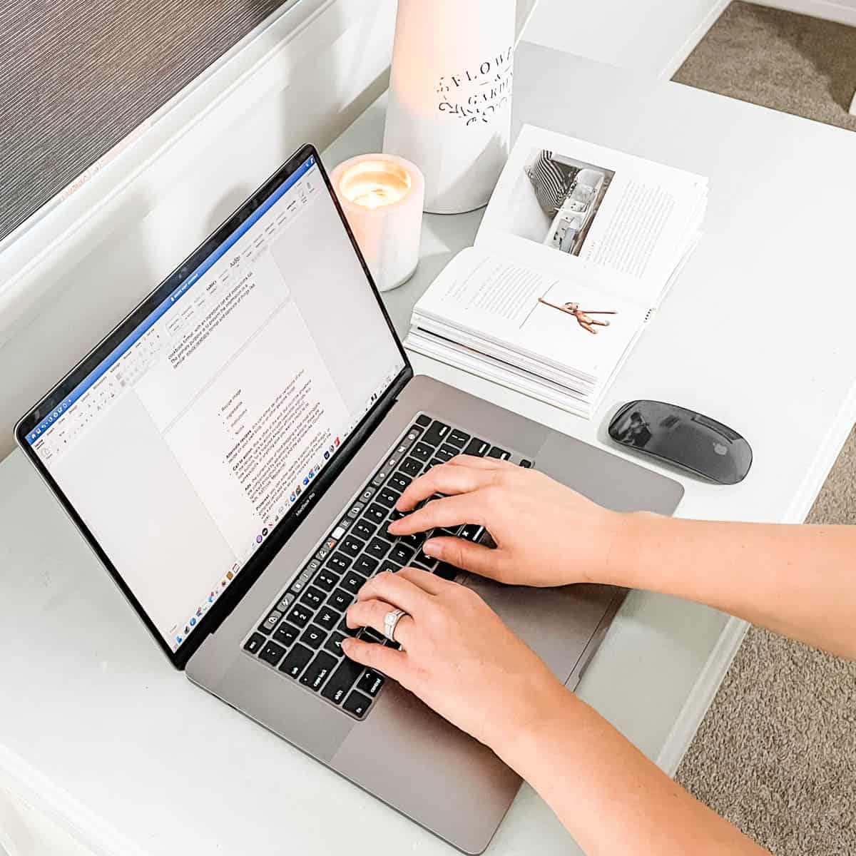 Image of hands of a person using a laptop on a desk