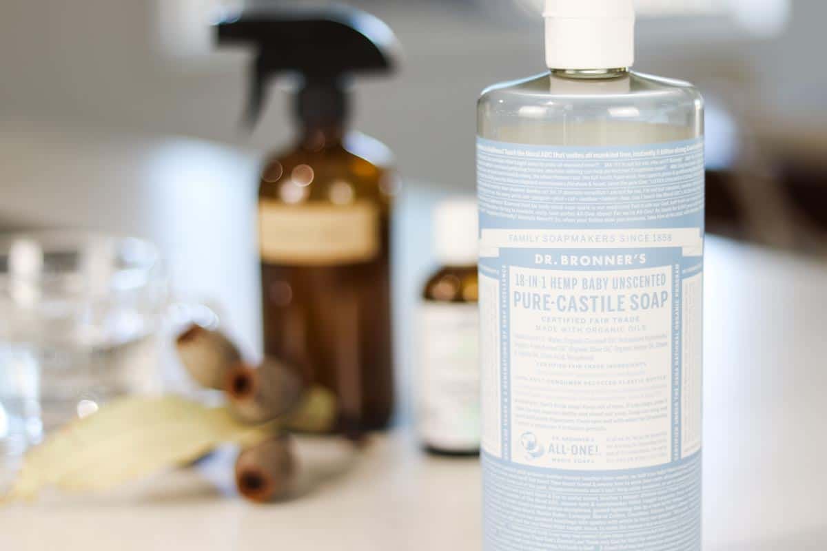Image of a bottle of liquid castile soap with other cleaning products in the background