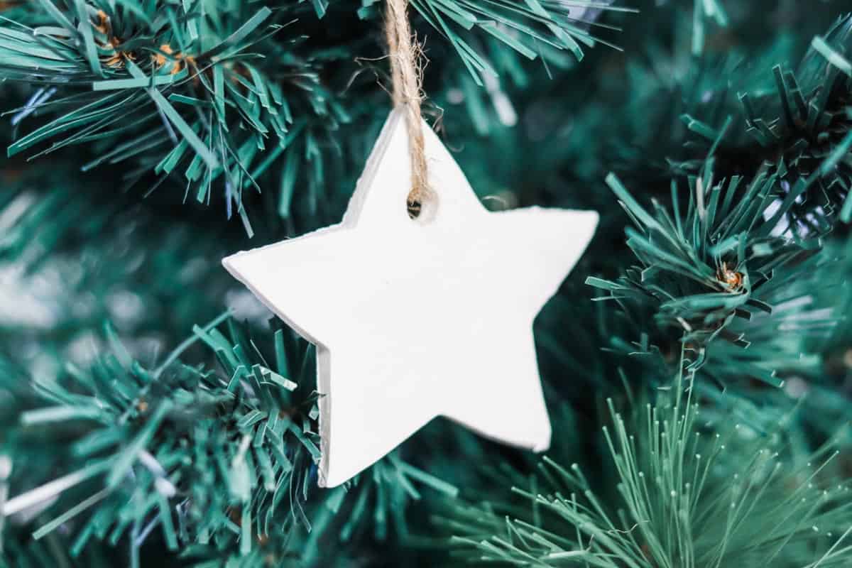 Close up image of a star shaped ornament hanging on a christmas tree