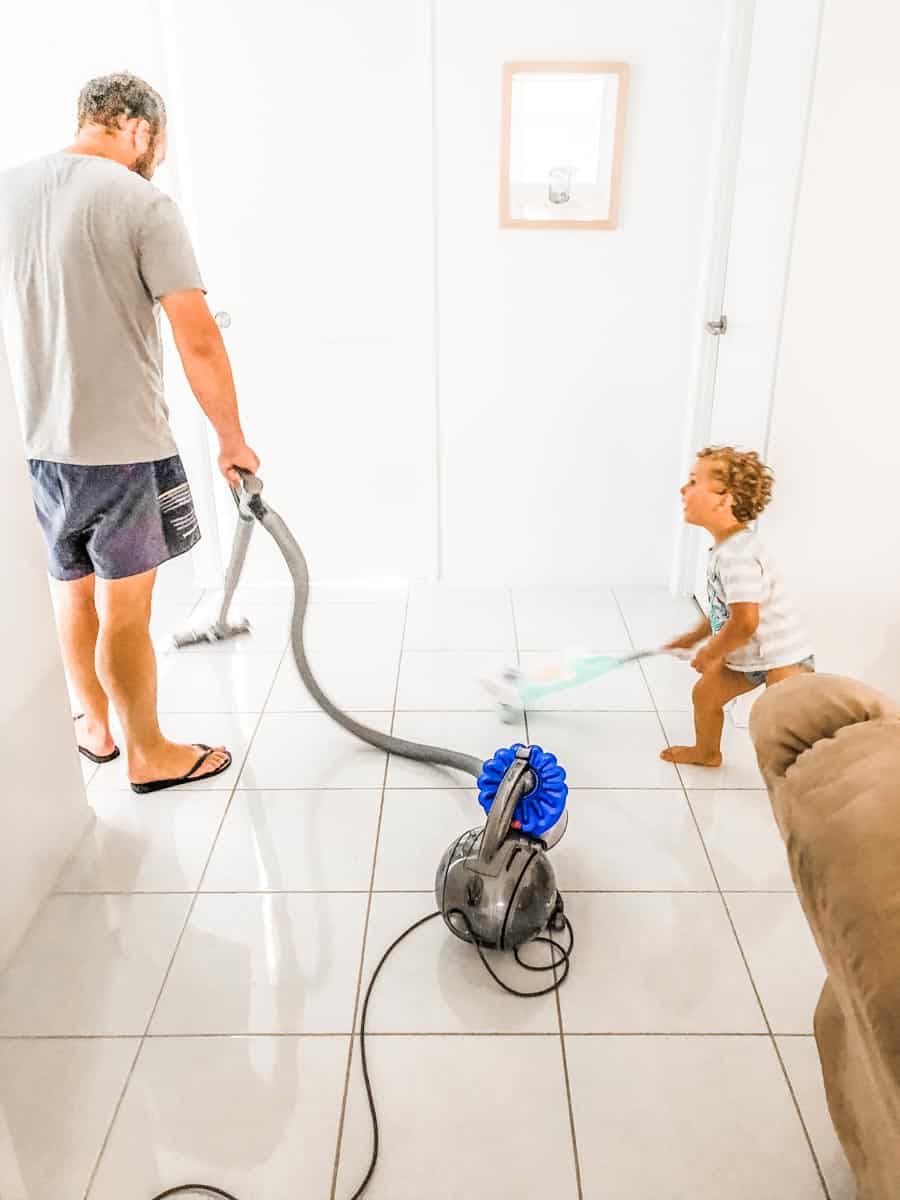  William vacuuming with daddy. William is using a toy vacuum while daddy cleans
