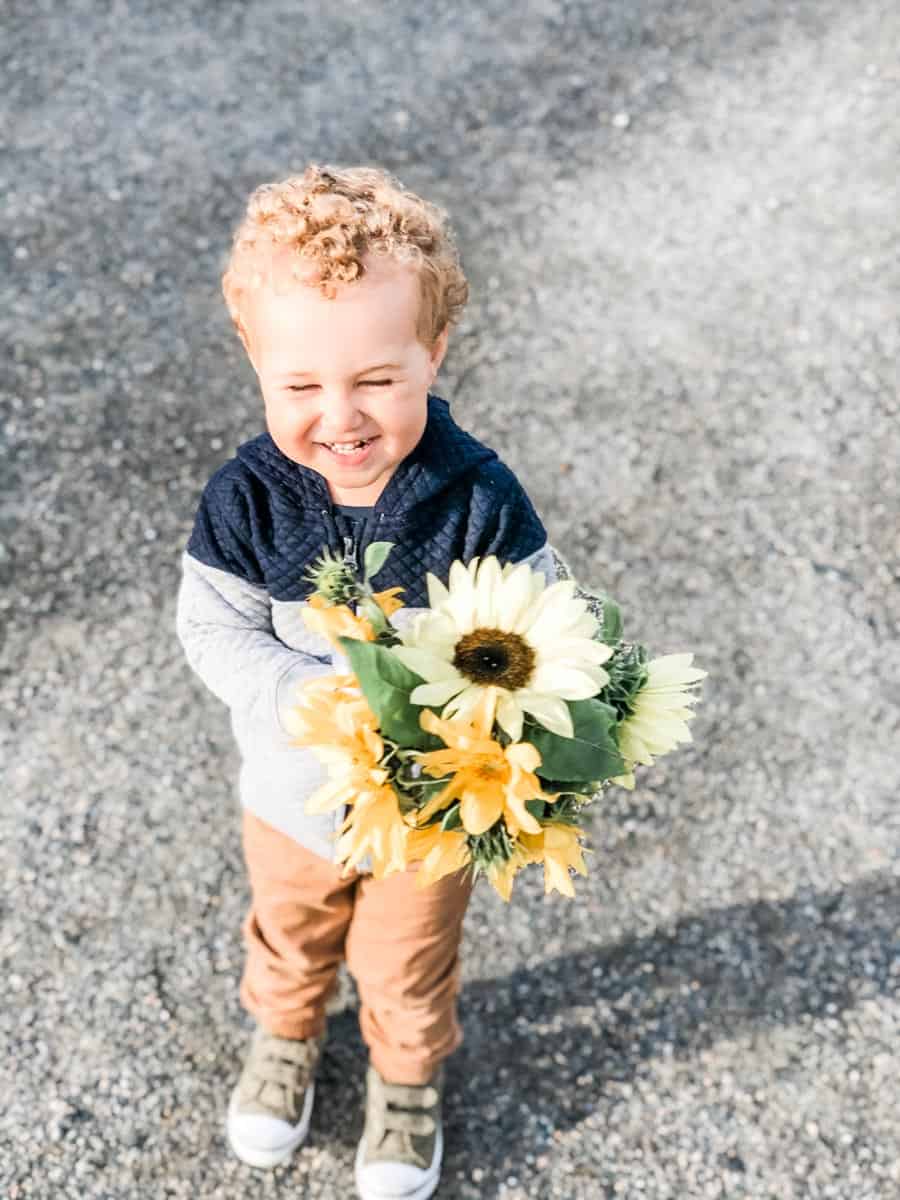 Image showing getting stuff done with toddler William at the markets. William is helping by crying a bunch of sunflowers.