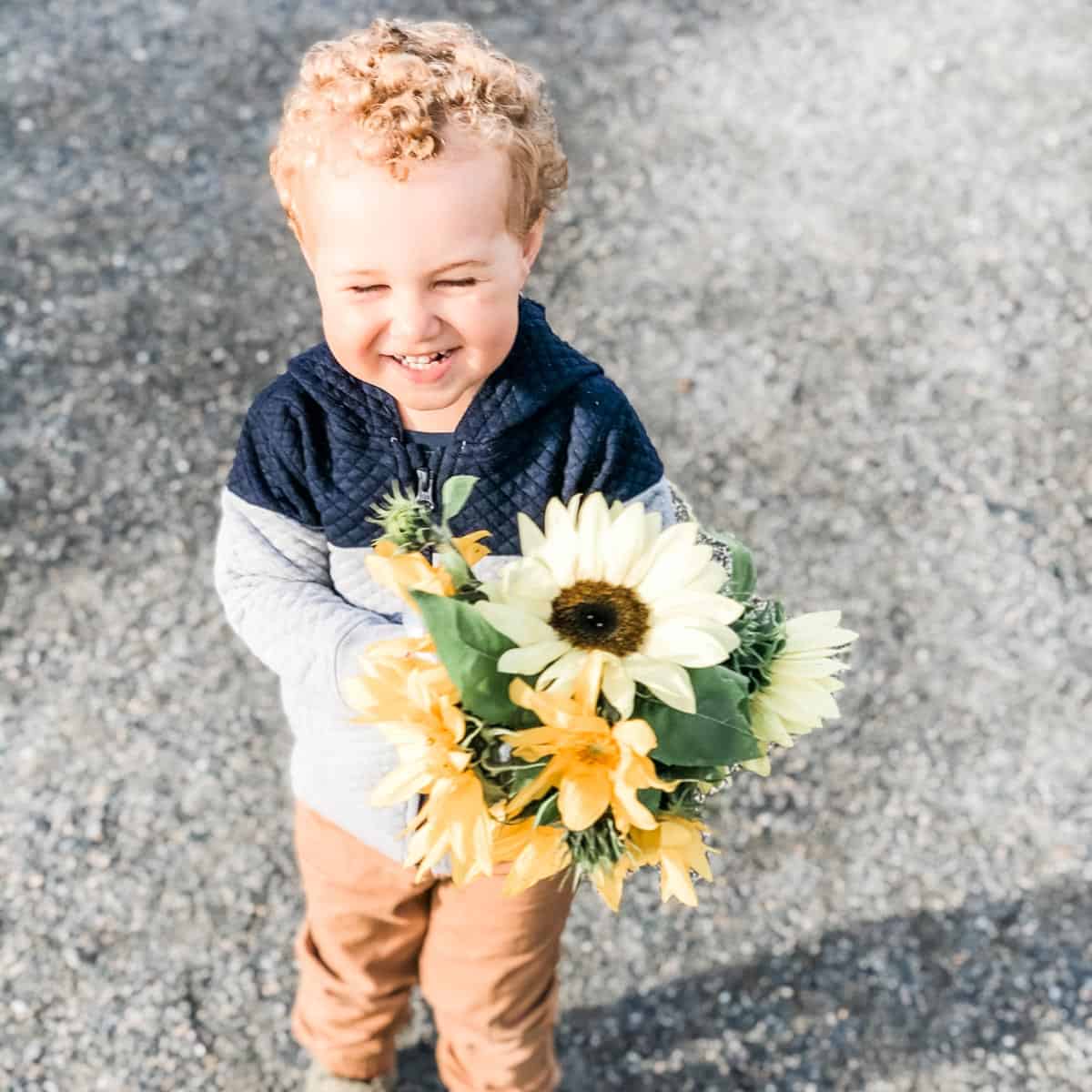 Image showing getting stuff done with toddler William at the markets. William is helping by crying a bunch of sunflowers.