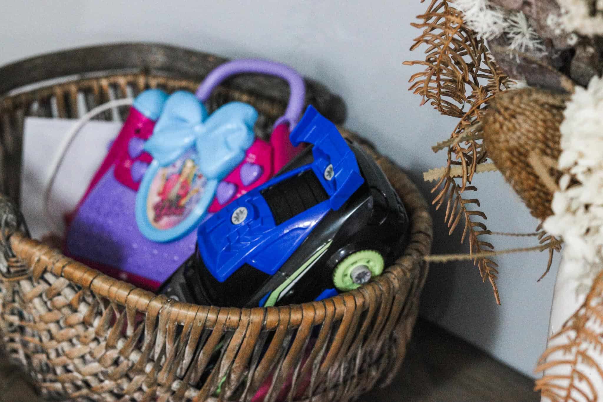 Close up image of a wicker basket filled with children's toys sitting upon a table