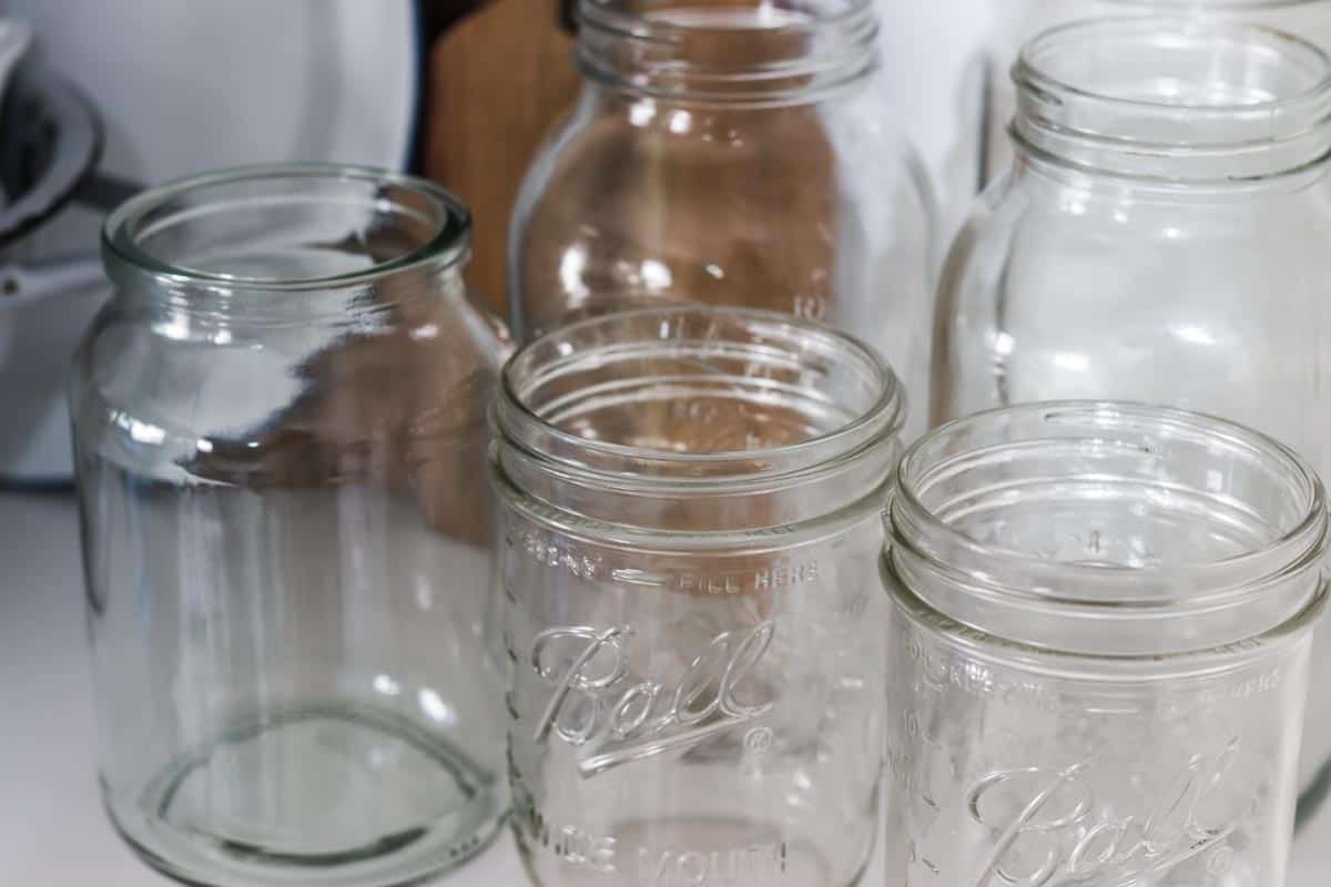 Close up image of a group of glass mason jars on a shelf