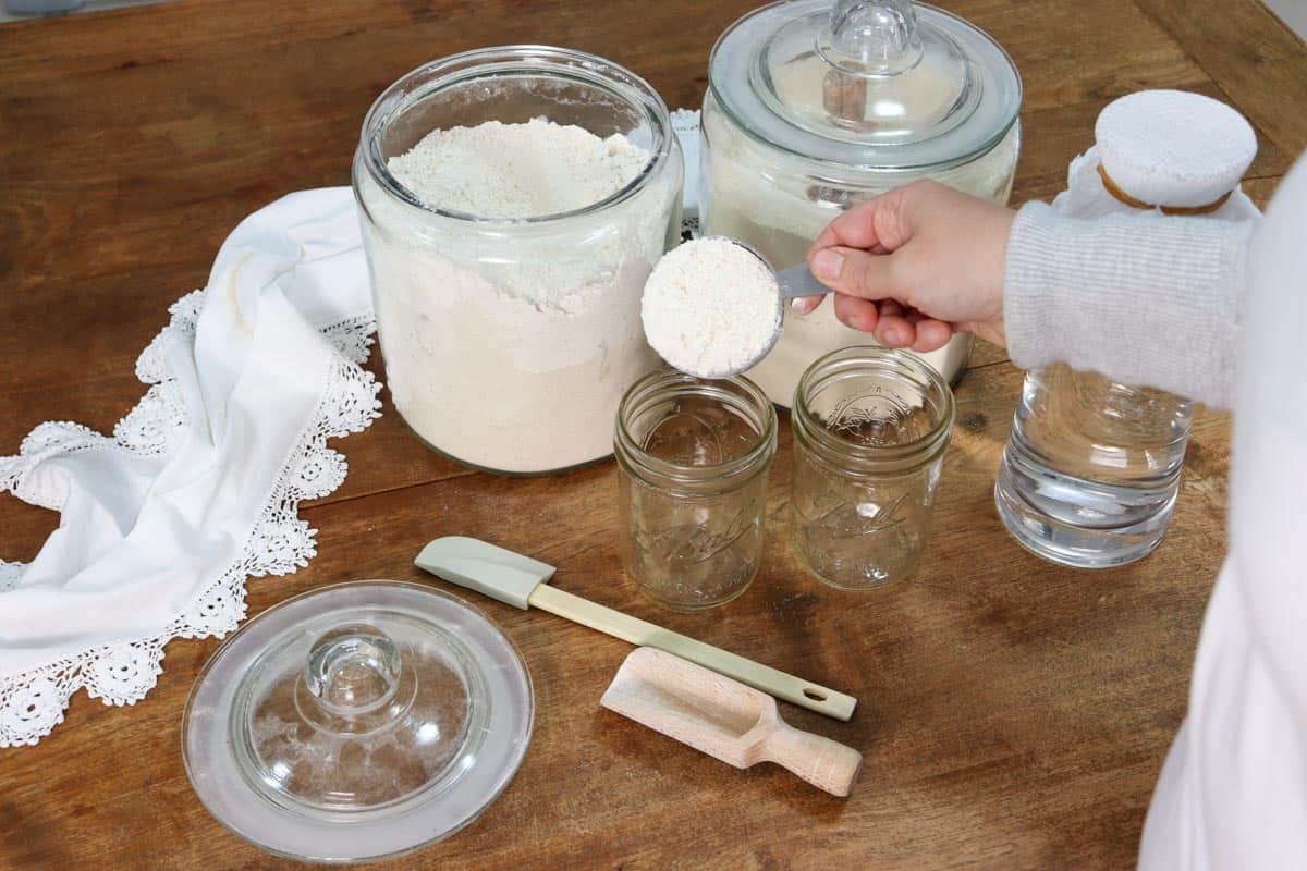 Adding a half a cup all purpose/plain flour to a glass mason jar to make sourdough starter