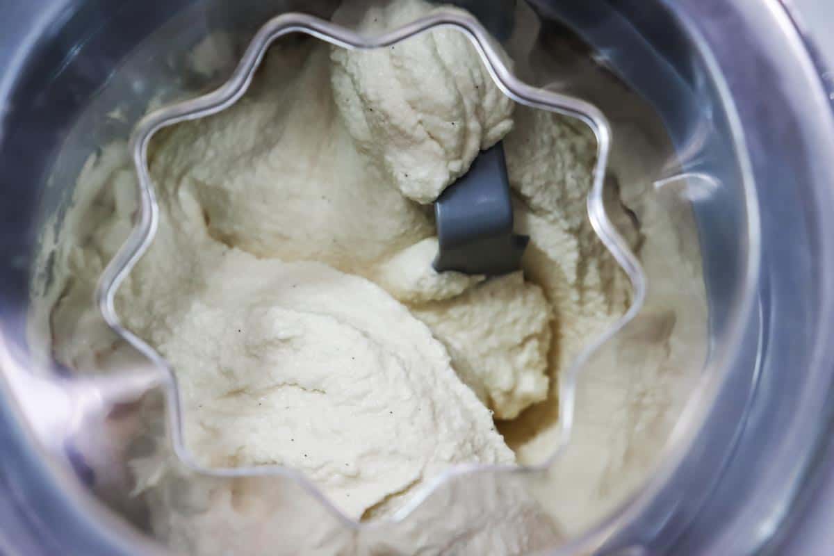 An overhead image showing vanilla ice cream in the ice cream machine at the end of churning