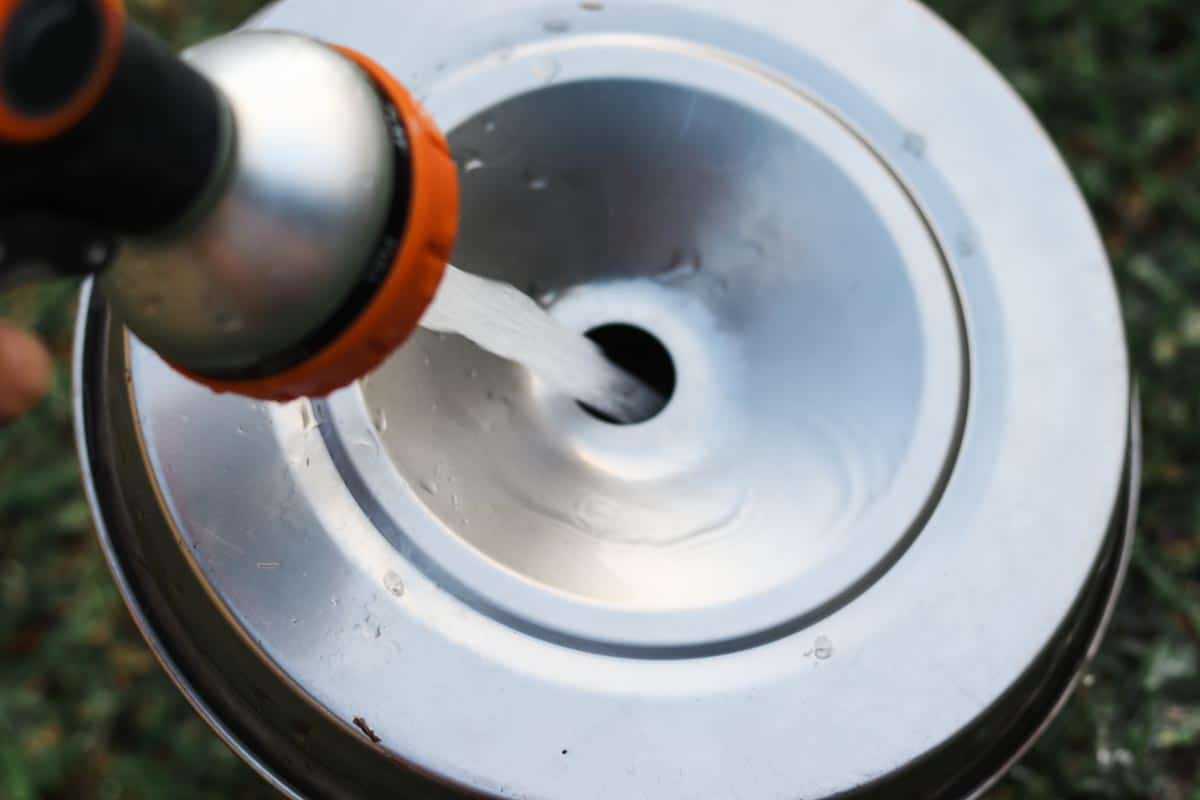 Filling the stainless steel chicken waterer with fresh clean water