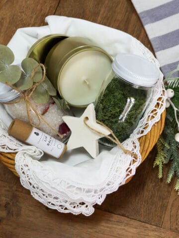 Christmas gift hamper basket with lip balm, bath salts, handmade baking soda ornament, dried herbs and a soy wax candle
