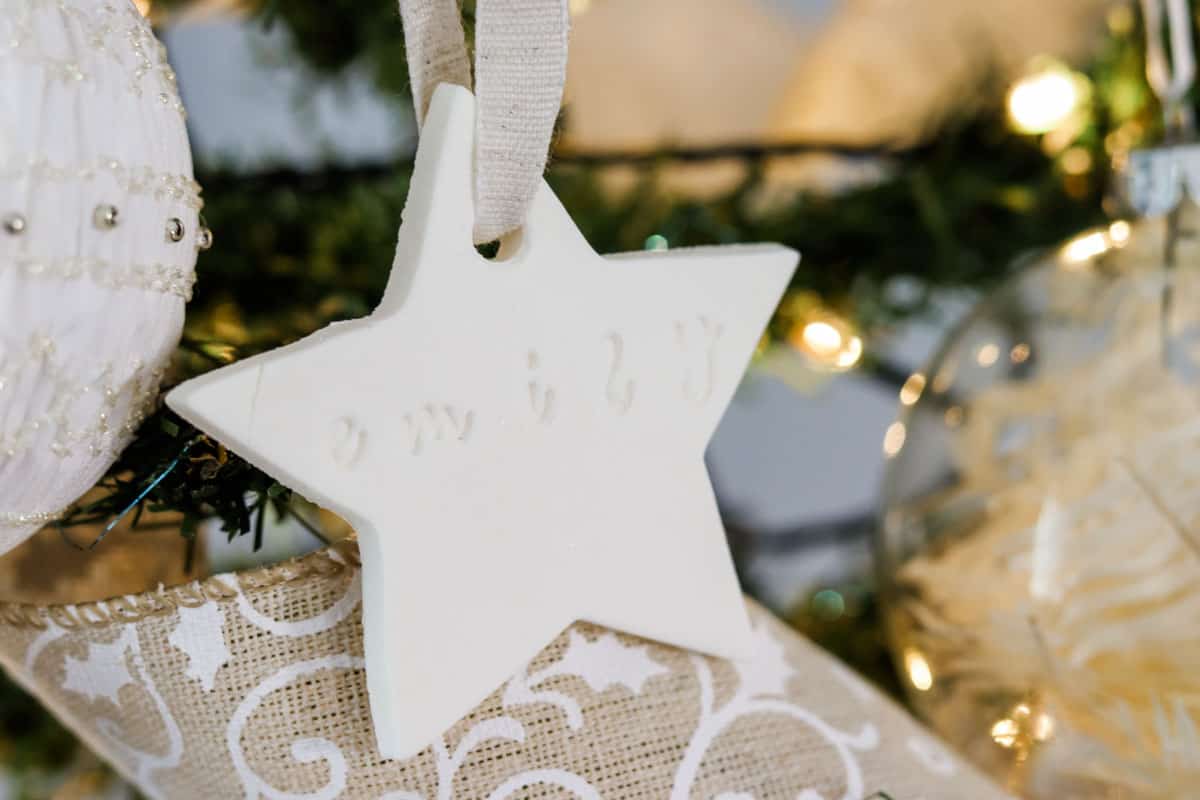 Homemade baking soda ornament in the shape of a star stamped with the word Emily