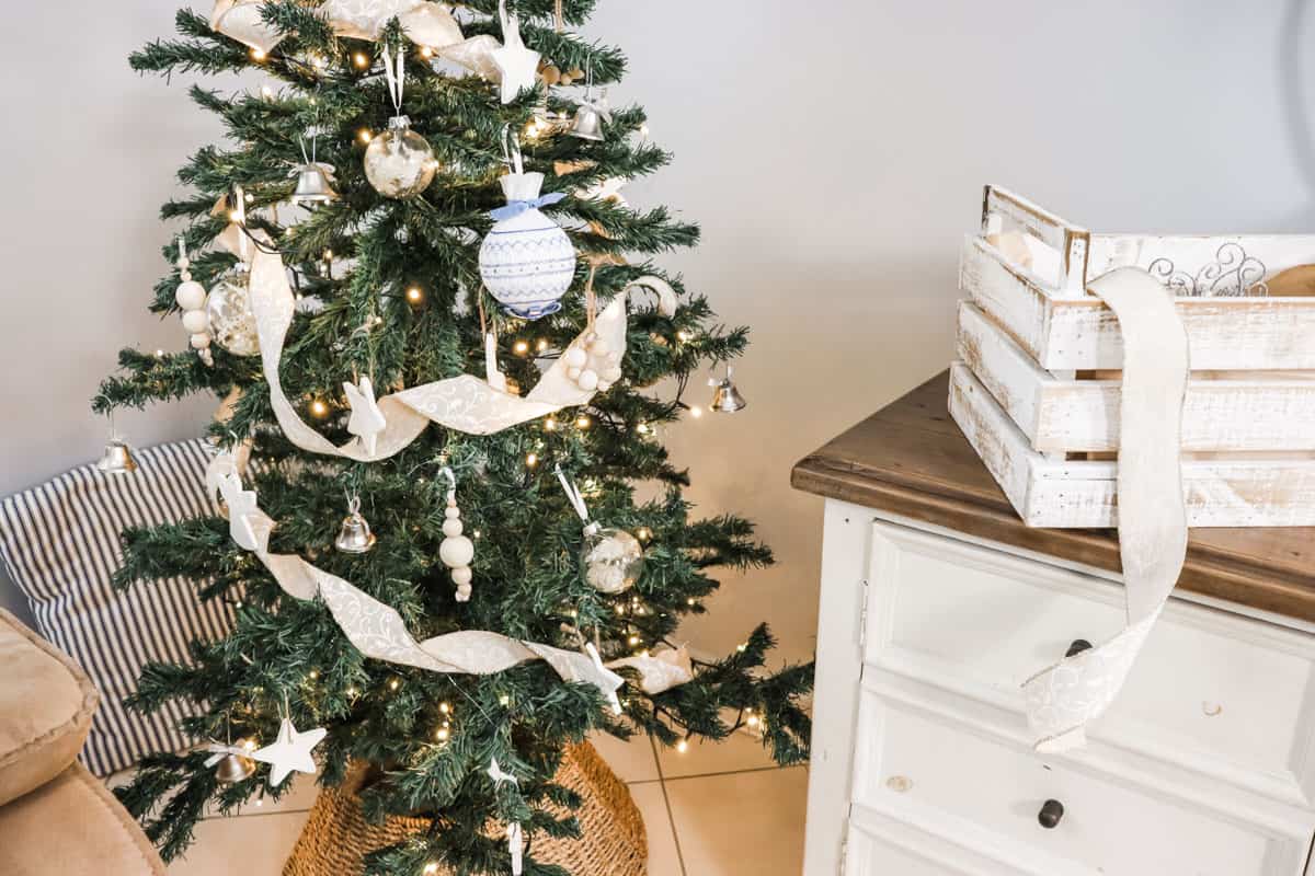 Cottage style Christmas tree set next to a box of decorations