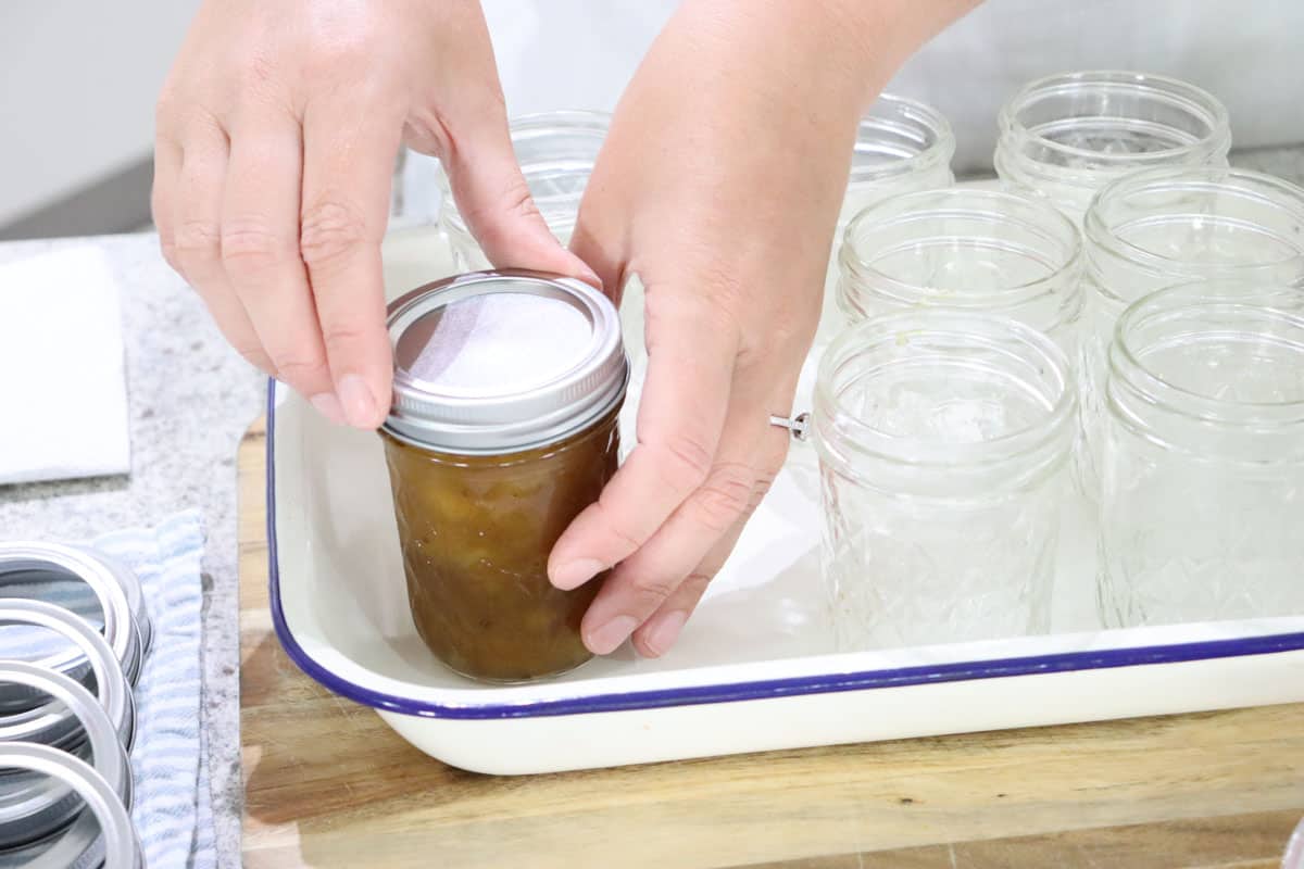 Adding the lid ring to the jar of mango chutney