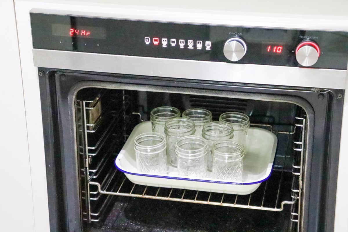 A tray of jars being place on a tray in the oven to be steralised