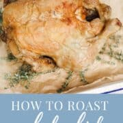 Pinterest graphic with an image of A roasted whole chicken on a tray with thyme and text "how to roast a whole chicken in the air fryer'