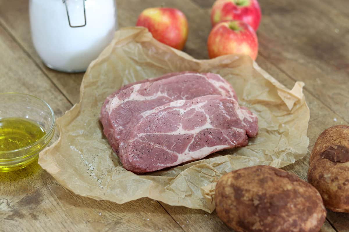 Raw pork steaks surrounded by other ingredients