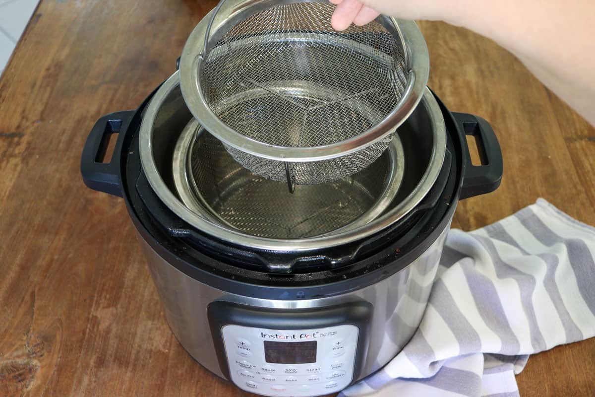 mesh baskets being placed in the air fryer