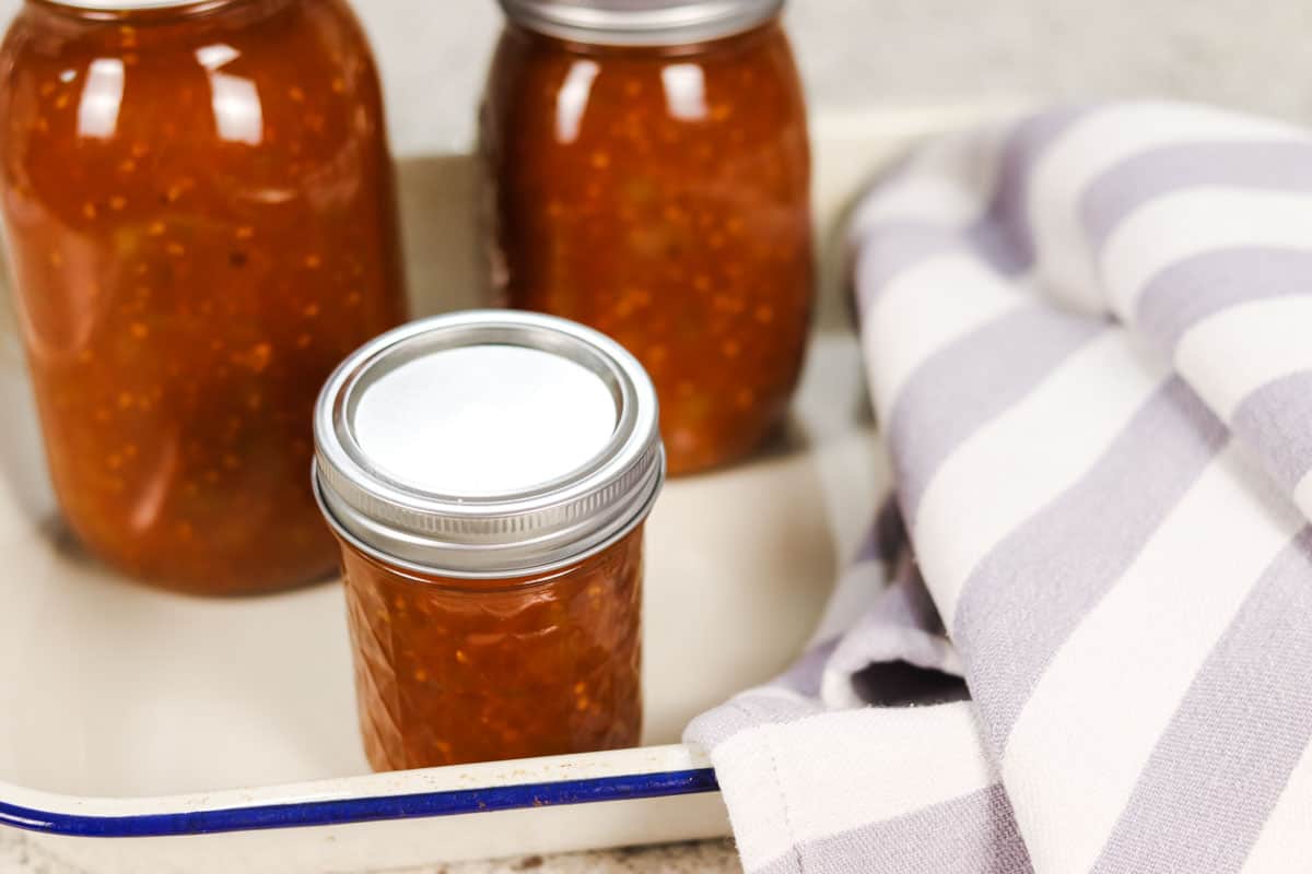 Close up image of three sealed jars of tomato relish after canning