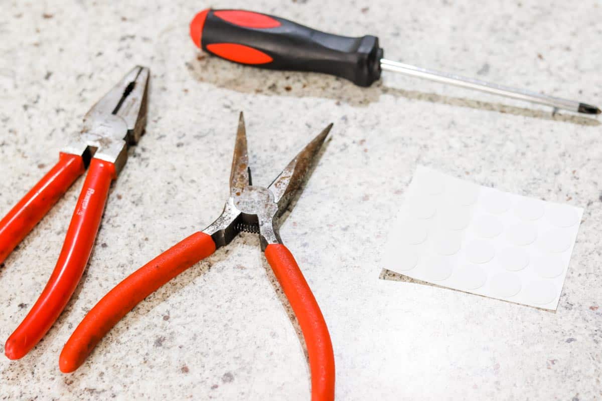 Pliers, a screwdriver and stick-on screw caps