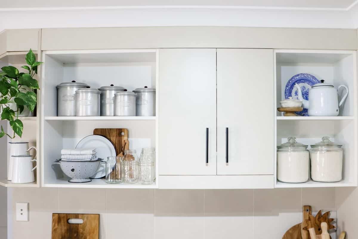 open shelves in a kitchen with a kitchen cabinet in the middle