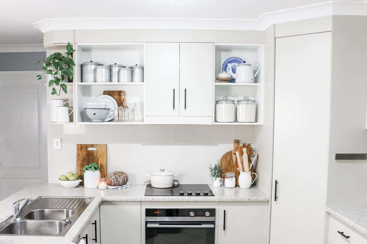 open shelving in a kitchen decorated with jars, dishes, canisters and ingredients