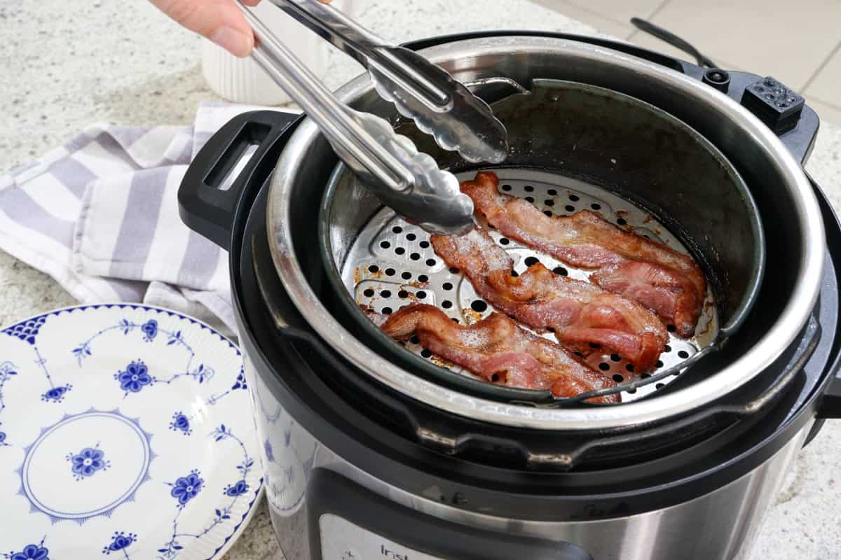 Cooked bacon is removed from the air fryer