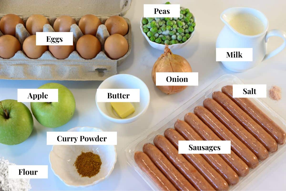 An image of the ingredients for old fashioned curried eggs and sausage with labels: eggs, peas, milk, onion, salt, apple, butter, curry powder, sausages, flour
