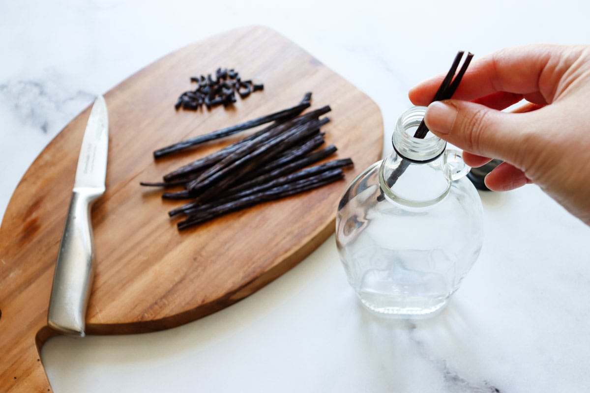 The sliced vanilla beans are placed in a recycled maple syrup bottle
