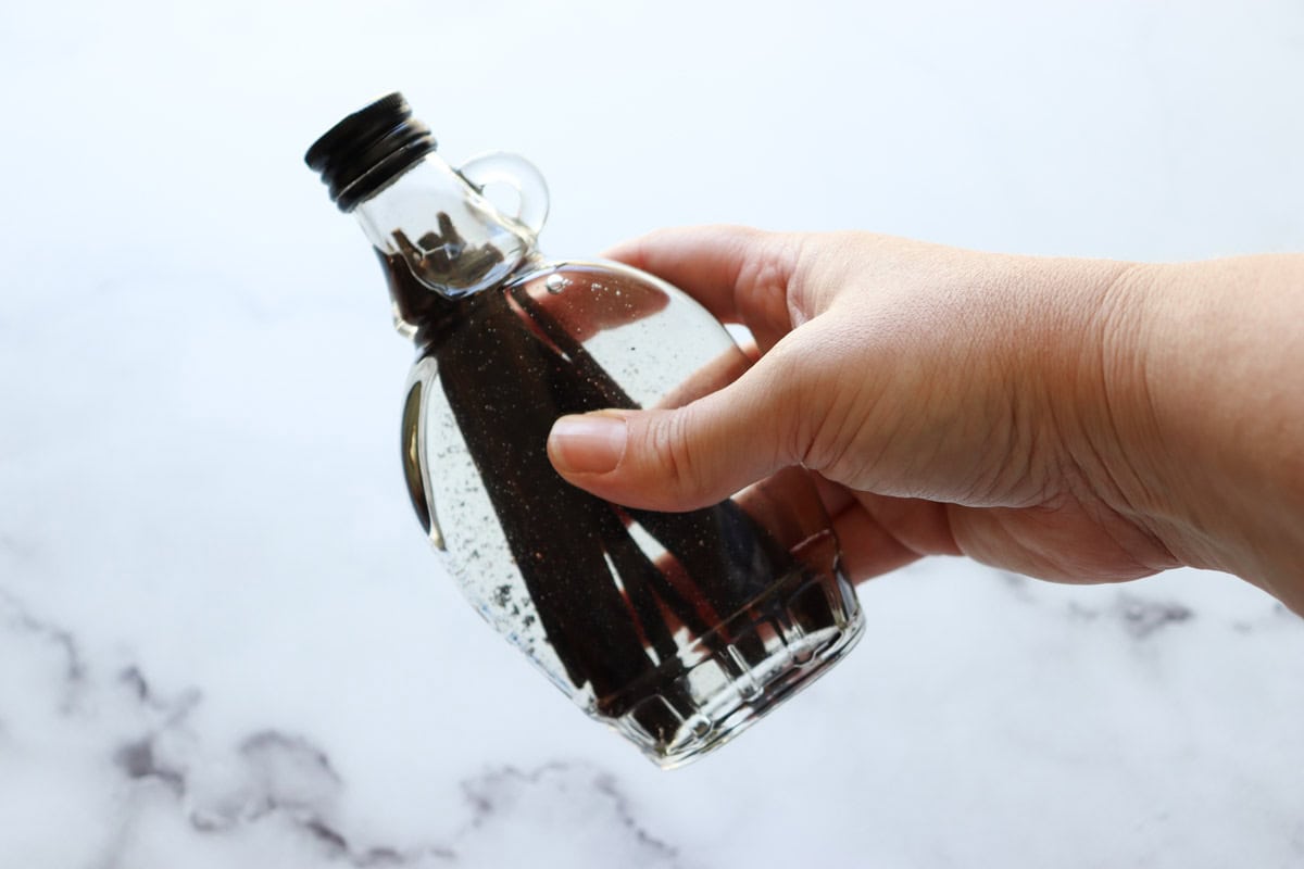 The vanilla extract is shaken to help the mixture infuse