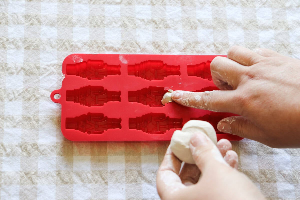 a small piece of clay is pressed into the bottom part of the mould