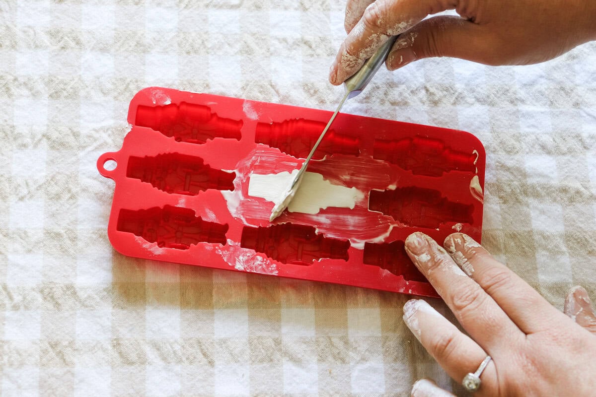 top of the clay being scraped flat in the mould using paring knife