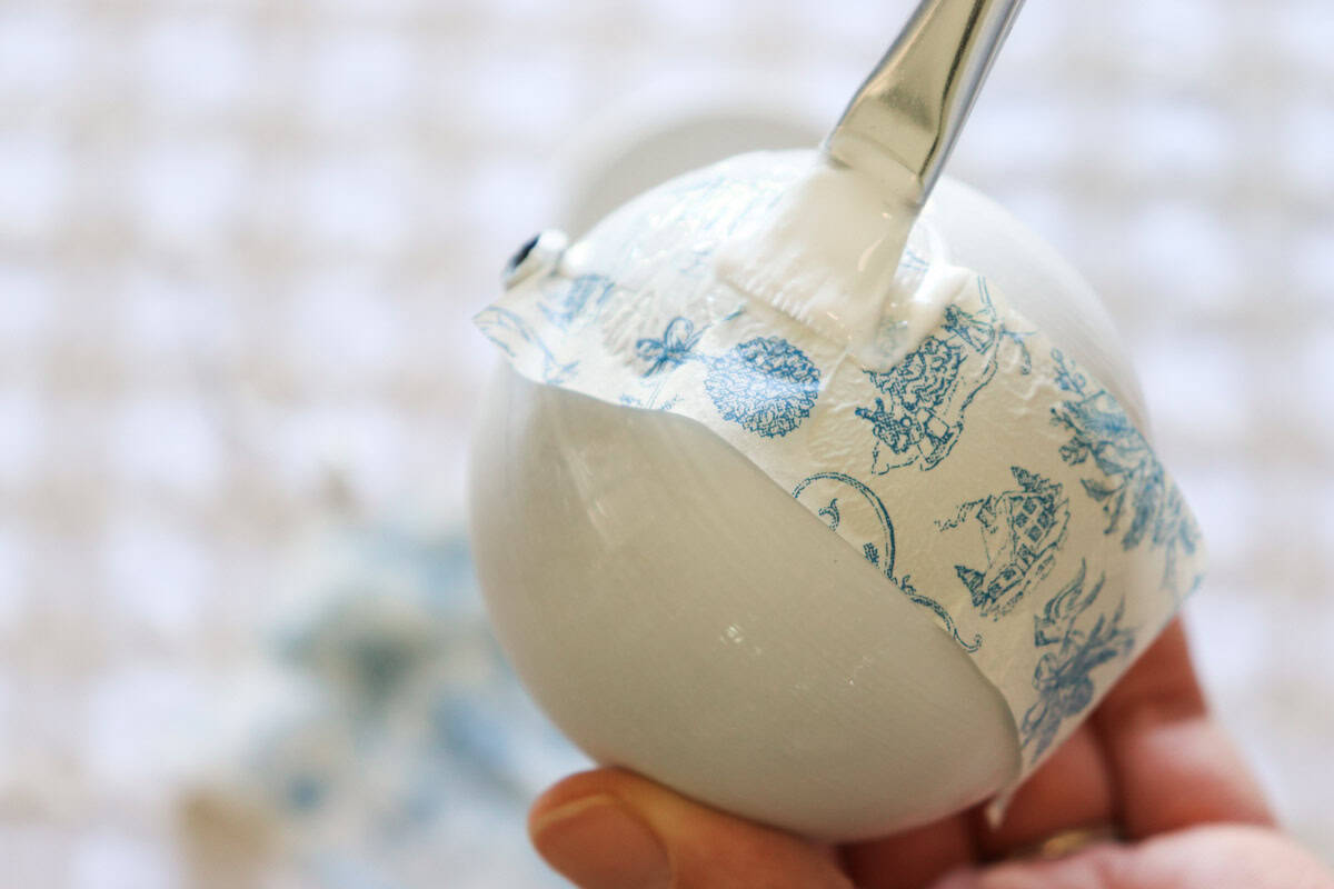 Glue is applied to the top of the napkin strip on the bauble