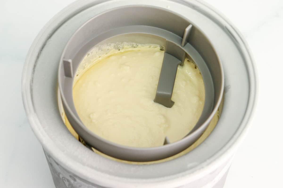 The ice cream has finished churning in the ice cream maker machine and is ready to freeze