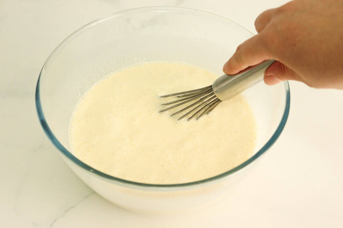 The cream and sweetened condensed milk mixture is whisked in a bowl