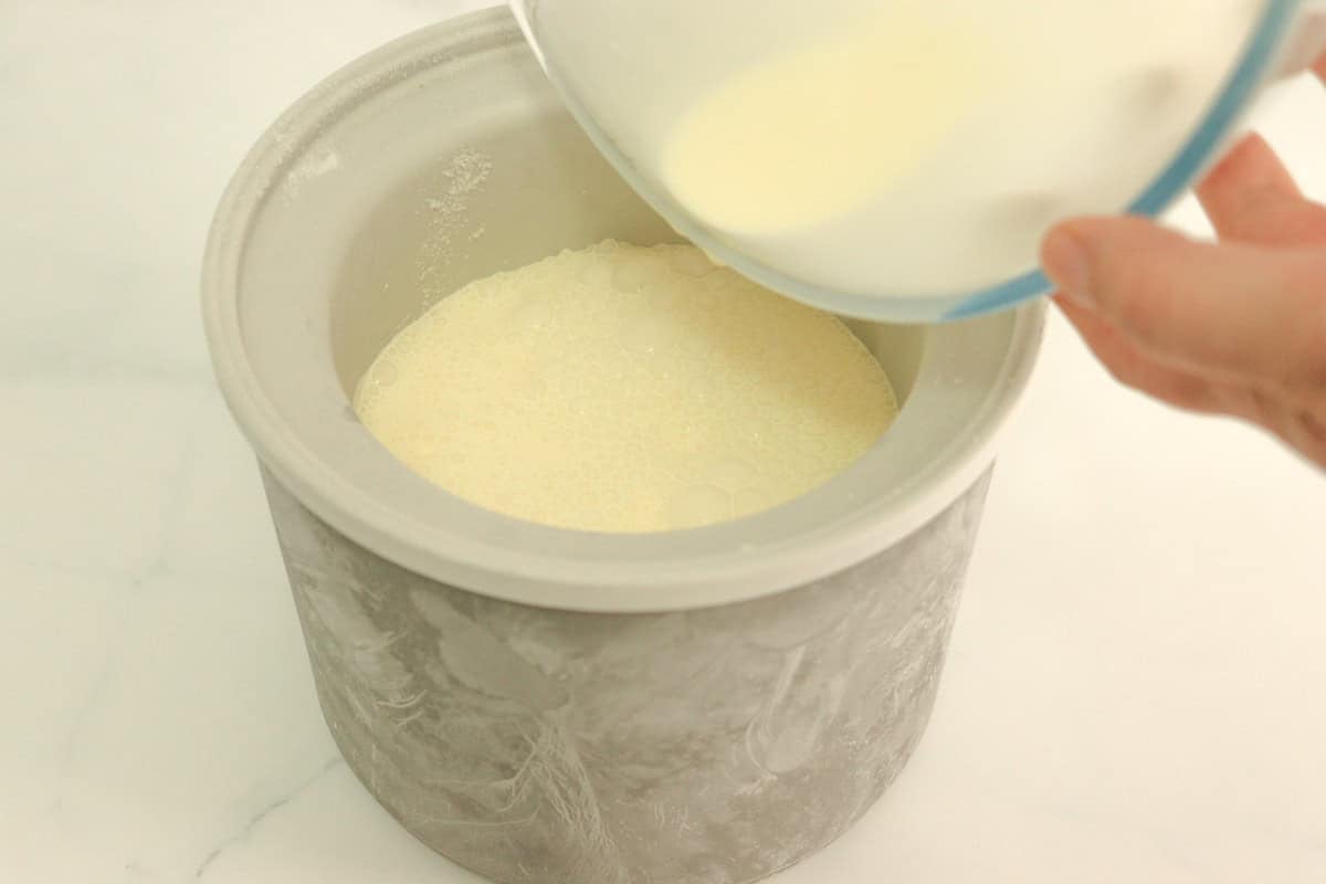 The cream and condensed milk mixture is poured into the frozen ice cream maker bowl ready for churning
