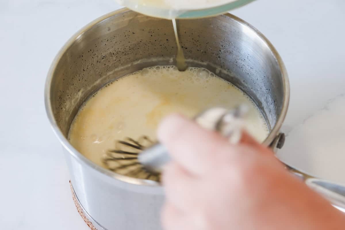 The tempered egg mixture is added to the milk, cream and vanilla mixture