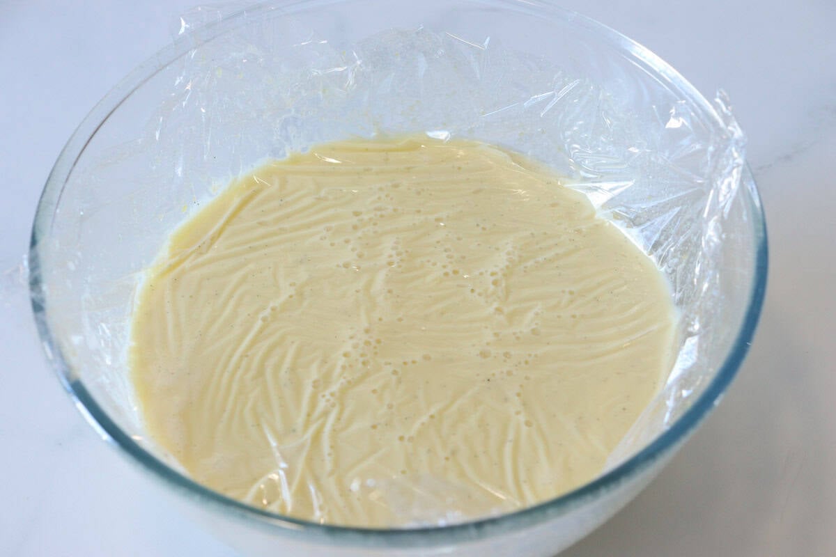 The custard is covered with plastic wrap directly on the surface to prevent a skin forming
