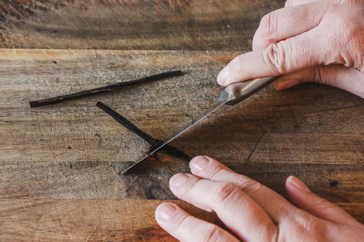 The vanilla bean is scraped to remove the seeds with a paring knife