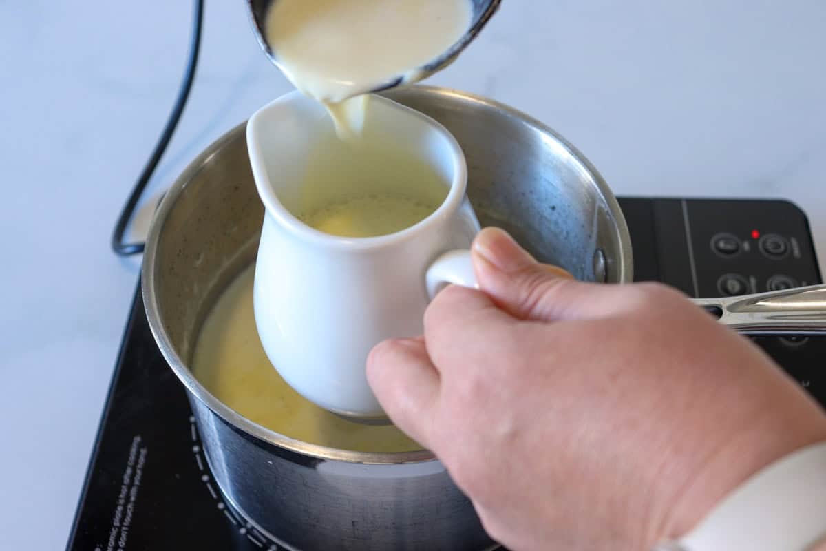 Hot milk, cream and vanilla mixture is added to a pouring jug