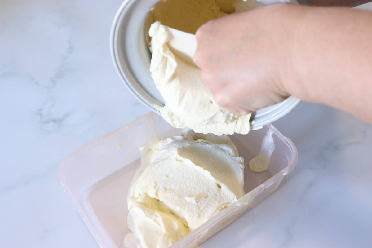 Custard base vanilla ice cream is transferred into a freezer safe container after churning