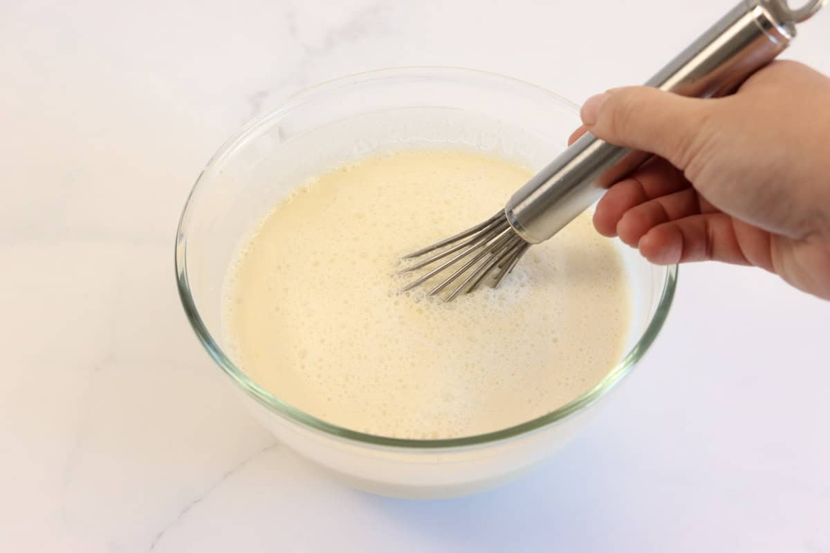 The cream, milk, maple syrup, eggs and vanilla is mixed in a bowl using a whisk