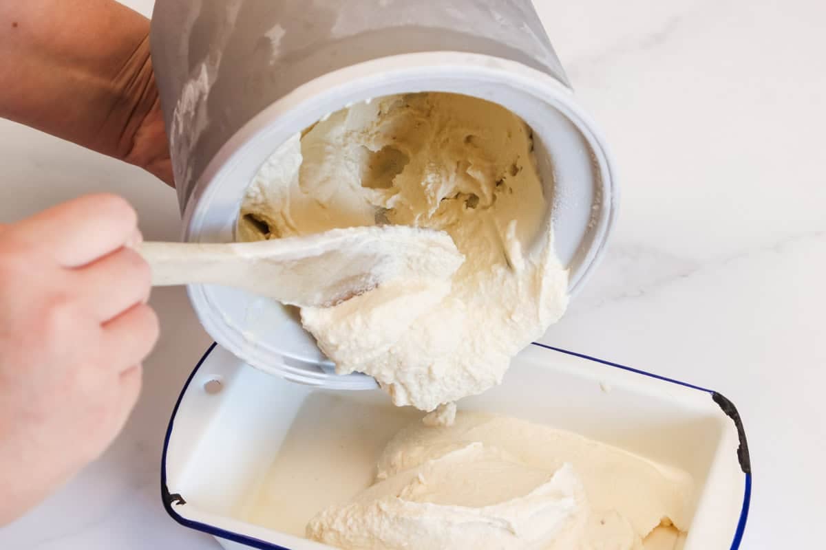 The churned ice cream is transferred into a container