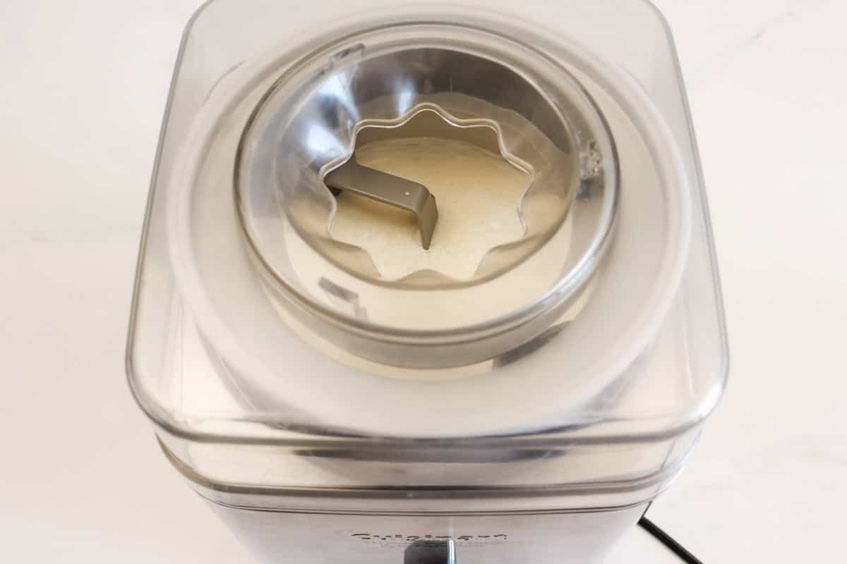 The ice cream mixture is churned in ice cream maker/machine