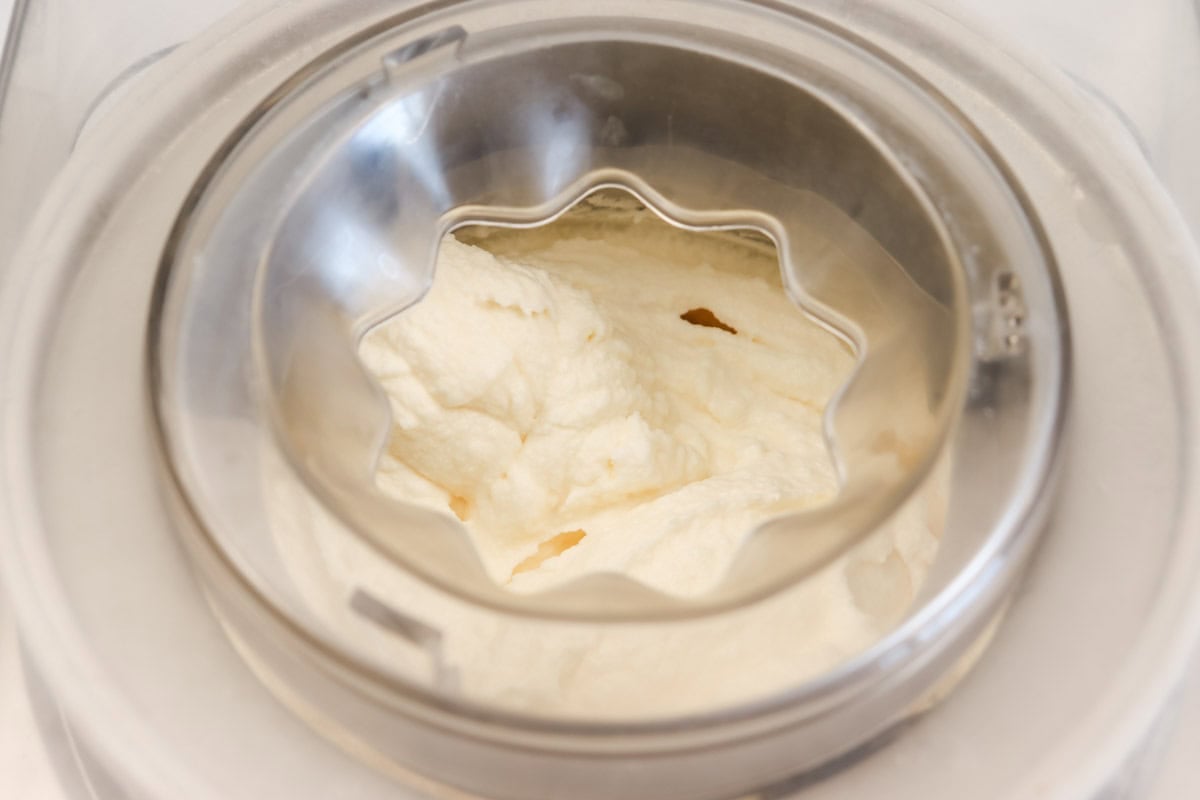 The ice cream has finished churning in the ice cream maker/machine and is thick
