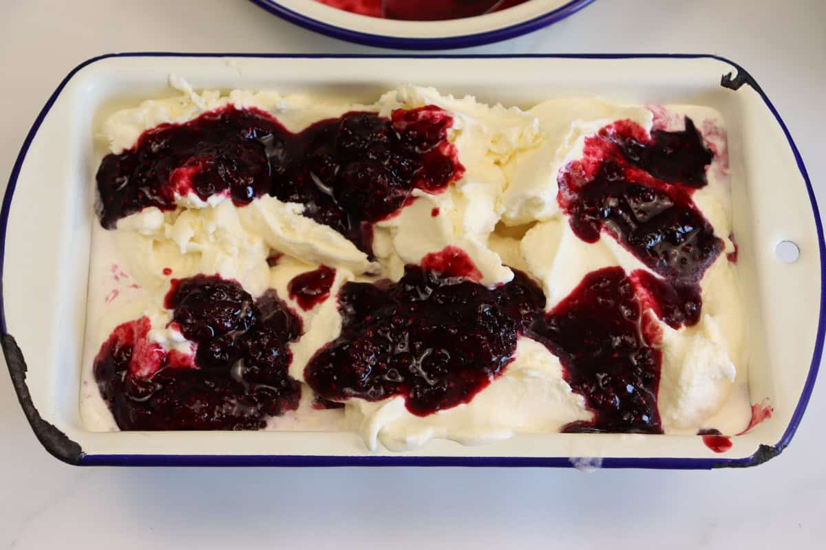 The second layer of berry sauce is added to the top layer of ice cream