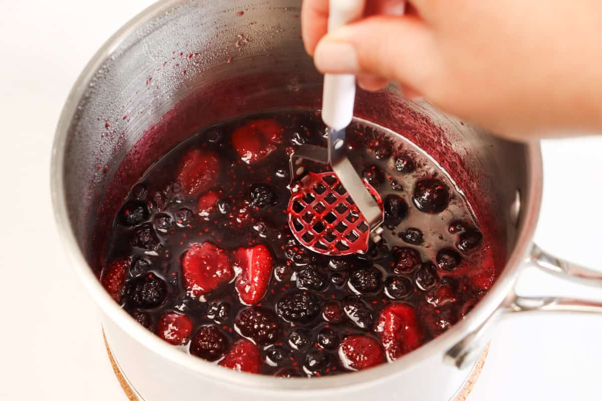 Mashing the berry sauce in the sauce