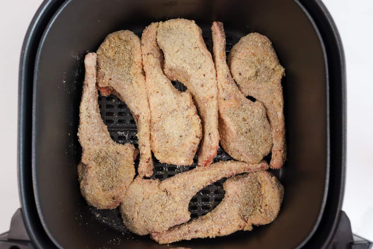 The crumbed lamb cutlets are place in the air fryer basket in a single layer