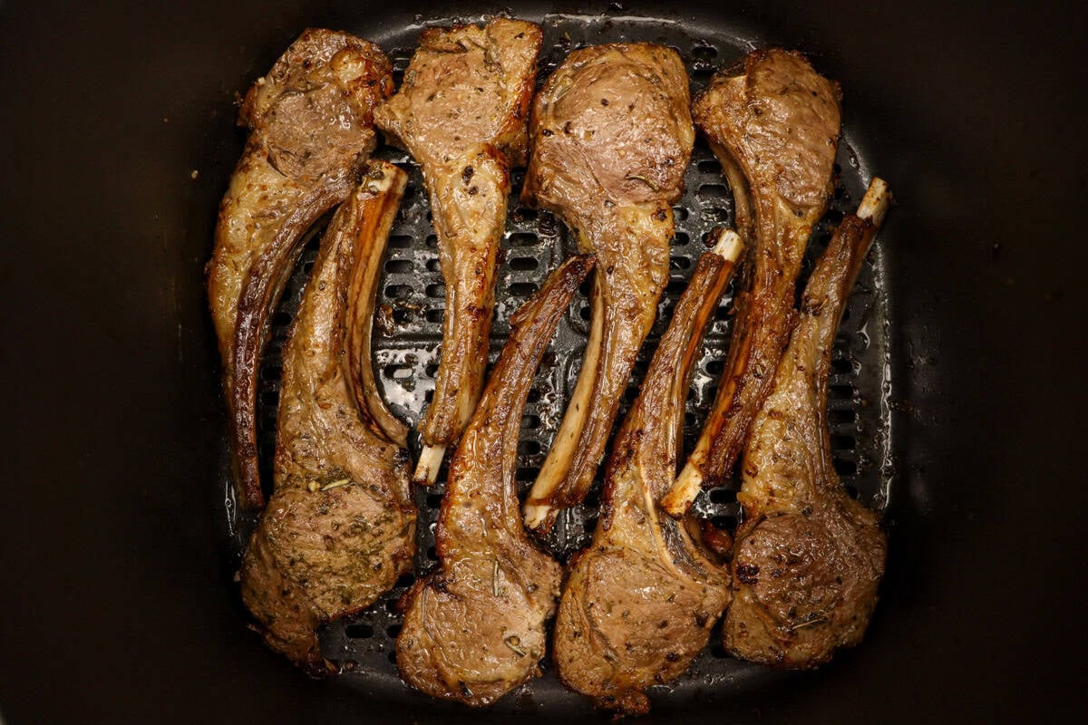 Cooked lamb cutlets sitting in the air fryer basket