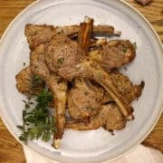 Lamb cutlets served on a plate with fresh oregano