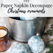 A graphic for Pinterest with an image of decoupage christmas ornaments in a metallic bowl with text "DIY Paper Napkin Decoupage Christmas Ornaments"